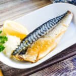 Japanese baked saba mackerel served on a plate with a lemon.