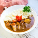 Japanese curry served on a plate over rice.