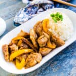 Soy garlic chicken served on top of a bed of rice topped with green onions.