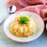 Soy garlic rice served in a bowl topped with green onions.