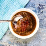Spicy soy garlic sauce being scooped out by a spoon.