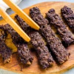 Beef teriyaki sticks served on a wooden plate.