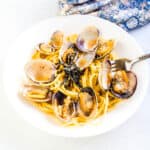 Japanese style clam pasta being picked up with a fork.