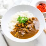Japanese mushroom curry served on a plate over rice.