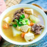 Miso stew topped with green onions served in a bowl.