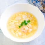 Seafood egg drop soup served in a bowl topped with green onions.