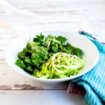 Salad being drizzled in rice vinaigrette dressing.