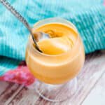Thai tea pudding being scooped out with a spoon.
