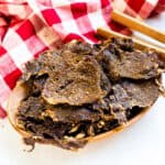 Cajun style beef jerky chips on a serving board.