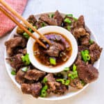 Slow cooked Japanese style pot roast being picked up with a pair of chopsticks.