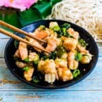 Shrimp poke being picked up with a pair of chopsticks.