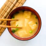 aAge fried tofu miso soup being scooped up with chopsticks.