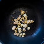 Chicken being cooked in a wok.