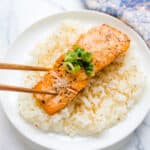 Yuzu seared salmon being picked up with a chopstick.