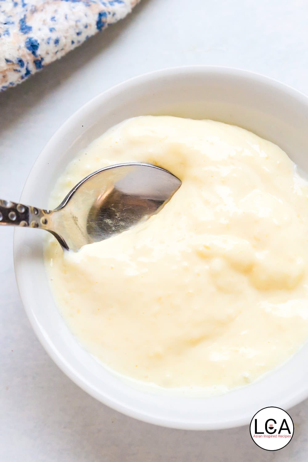 Lemon garlic aioli is sc with a spoon.