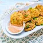 Crab cakes being dipped into Old Bay aioli dipping sauce.