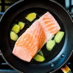 Salmon being cooked in Japanese broth.