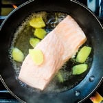 Salmon being cooked in Japanese broth.