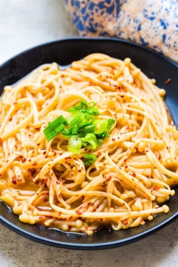 Simmered garlic enoki mushroom served on a plate.