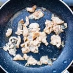 Sliced pork being cooked in a wok.