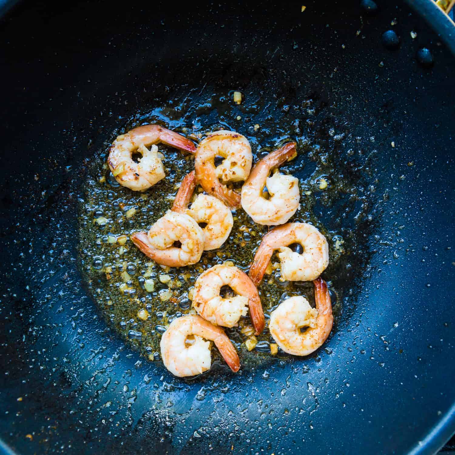 Shrimp are cooking in the pan. 