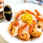 Pepper Lunch sauce being drizzled on shrimp.