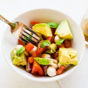 Pick up the avocado mozzarella salad with a fork.