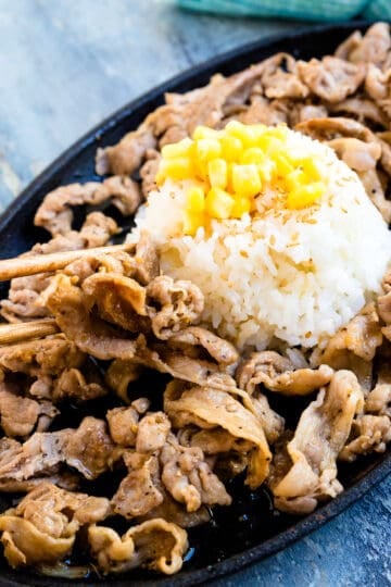 Pepper Lunch pork being picked up with a pair of chopsticks.