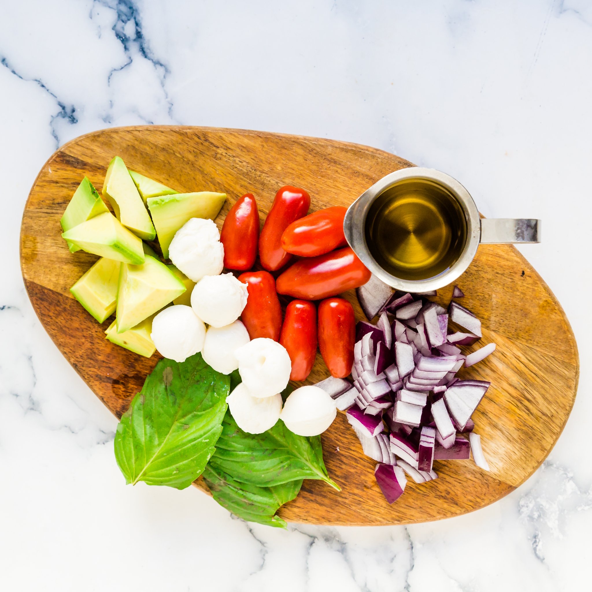 Make the ingredients for the Avocado Mozzarella Salad on the countertop. 